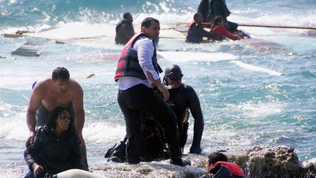 Anwohner helfen erschöpften Flüchtlingen an der Küste von Rhodos.(Archivbild) EU-Ratschef Donald Tusk will den Zustrom von Flüchtlingen in die EU durch eine drastische Ausdehnung der Prüfzeit auf 18 Monate bremsen.
