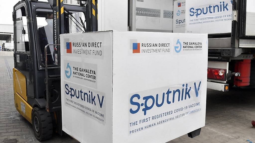 ARCHIV - Kisten mit Dosen des russischen Corona-Impfstoffs Sputnik V werden in einem Lagerhaus des ungarischen Pharmagroßhändlers Hungaropharma mit einem Gabelstapler aus einem Lastwagen geladen. Foto: Zoltan Mathe/MTI/AP/dpa