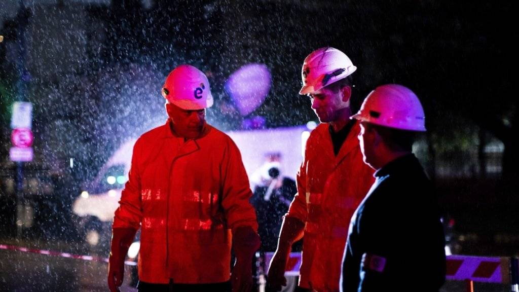 Mitarbeiter einer Energiefirma bei der Arbeit im Regen in der argentinischen Hauptstadt Buenos Aires.