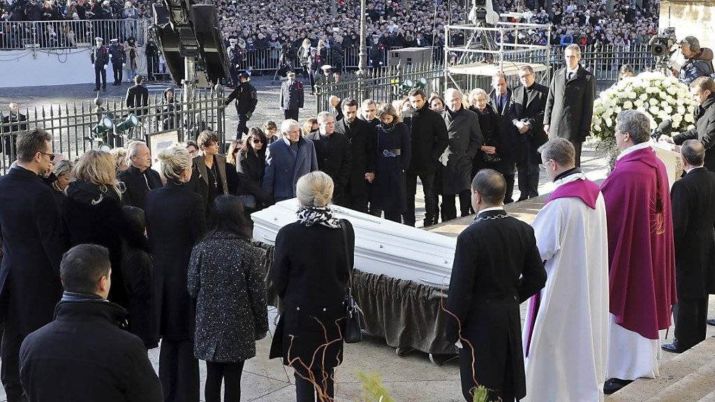 Angehörige von Johnny Hallyday stehen vor der Madeleine-Kirche in Paris um den Sarg des verstorbenen Sängers.