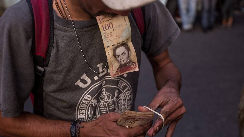 Ein Mann bündelt seine Geldscheine in Caracas.