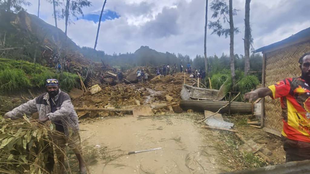 HANDOUT - Auf diesem von der Internationalen Organisation für Migration via AP zur Verfügung gestellten Foto suchen Dorfbewohner nach einem Erdrutsch im Dorf Yambali. Foto: Mohamud Omer/International Organization for Migration/AP/dpa - ACHTUNG: Nur zur redaktionellen Verwendung und nur mit vollständiger Nennung des vorstehenden Credits