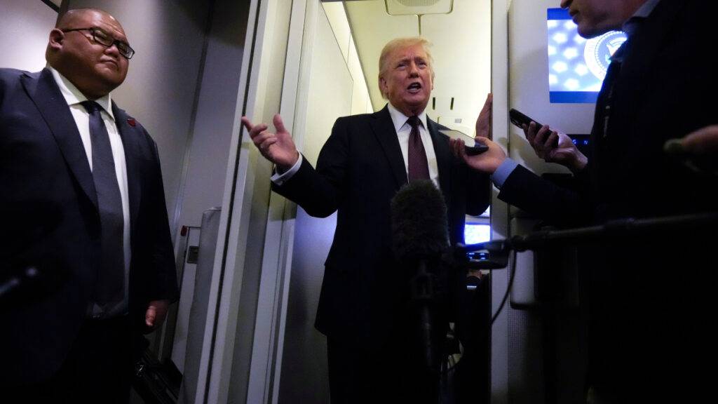 US-Präsident Donald Trump spricht zu Reportern an Bord der Air Force One. Foto: Mark Schiefelbein/AP/dpa