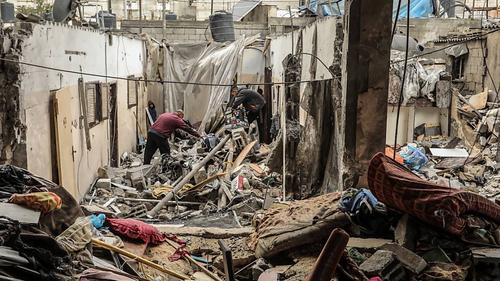 Palästinenser suchen inmitten der Trümmer ihres nach israelischem Bombardement zerstörten Hauses nach Überresten ihres Besitzes. Foto: Abed Rahim Khatib/dpa