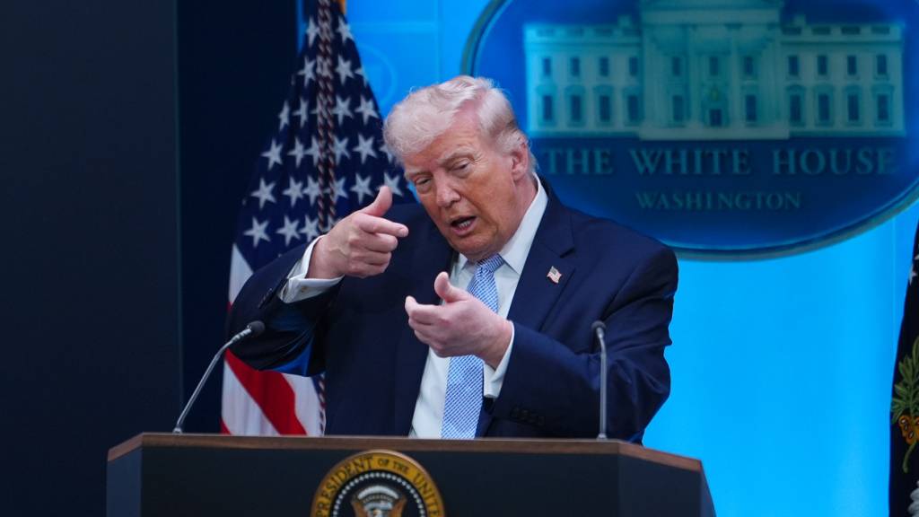 US-Präsident Donald Trump tut während einer Pressekonferenz im Weißen Haus so, als ziele er mit einem Scharfschützengewehr. Foto: Julia Demaree Nikhinson/AP/dpa