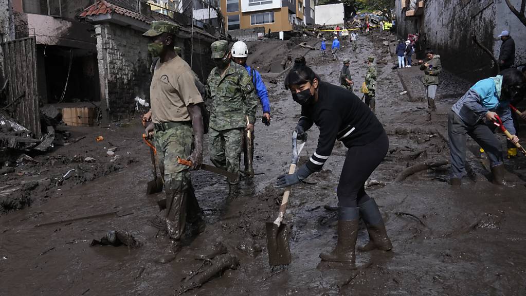 Anwohner und Soldaten in Ecuadors Hauptstadt Quito arbeiten daran, die Strassen von Schlamm zu befreien.