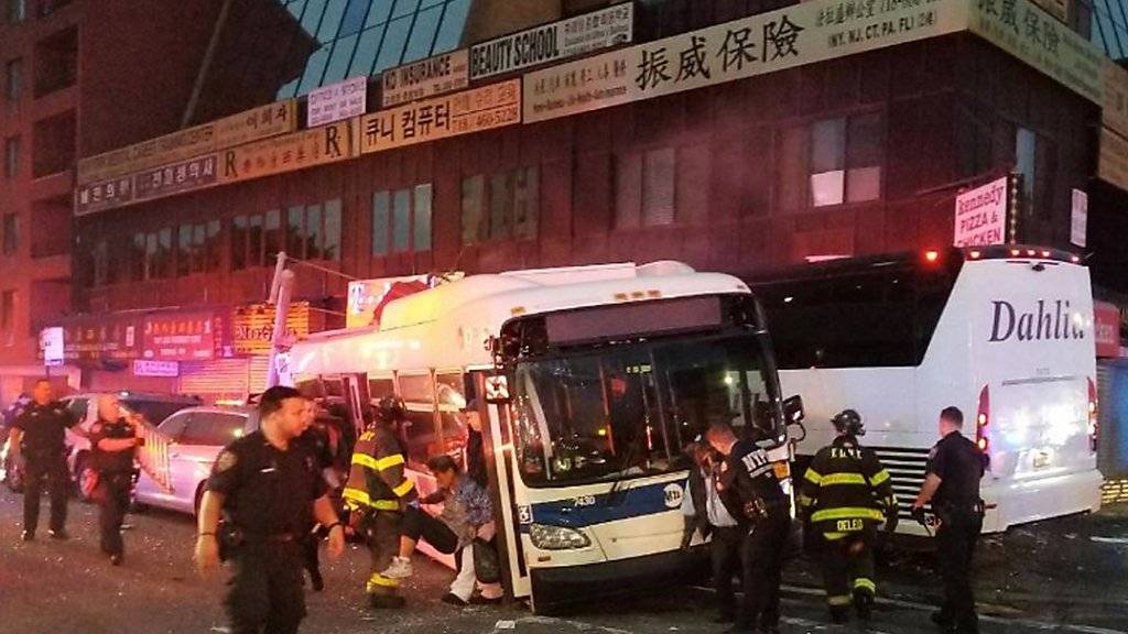 Nach der Kollision zweier Busse in New York sind Polizisten und Feuerwehrmänner im Einsatz.
