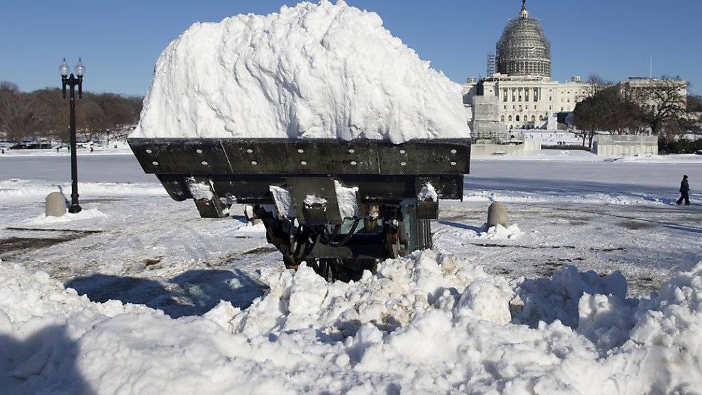Eine Maschine lädt Schnee vor dem Kapitol in Washington ab.