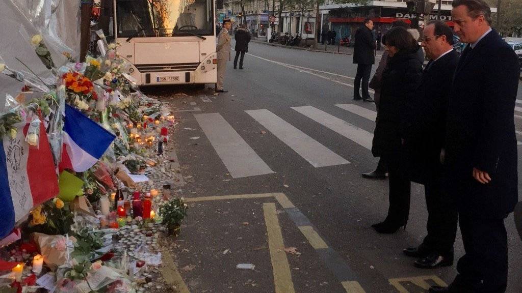 Gemeinsam Blumen niedergelegt: Frankreichs Präsident François Hollande (2. v. r.) und der britische Premierminister David Cameron (r.) vor dem Bataclan, wo am 13. November 89 Menschen getötet worden waren (Quelle: Twitter-Account von Cameron)