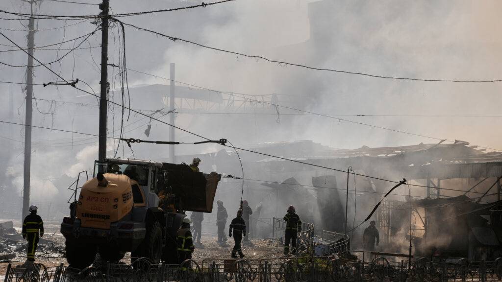 Feuerwehrleute löschen das Feuer auf einem Marktplatz in Kiew. Foto: Efrem Lukatsky/AP/dpa