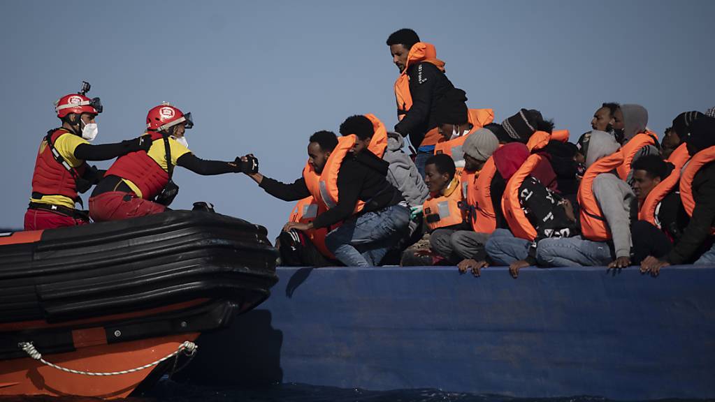 ARCHIV - Migranten aus Eritrea, Ägypten, Syrien und dem Sudan werden an Bord eines Holzbootes im Mittelmeer etwa 110 Meilen nördlich von Libyen darauf, von Helfern der spanischen NGO «Open Arms» unterstützt. (Illustration zu dpa: «Hilfsorganisation Open Arms rettet mehr als 30 Bootsmigranten») Foto: Joan Mateu/AP/dpa