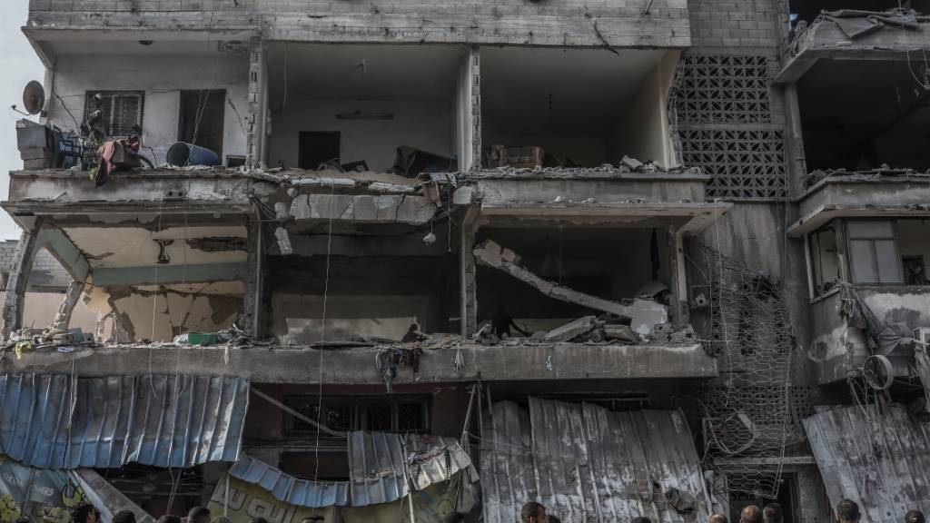 Palästinenser stehen nach einem israelischen Angriff auf Gaza-Stadt vor den Trümmern eines Gebäudes. Foto: Mohammed Abu Elsebah/dpa