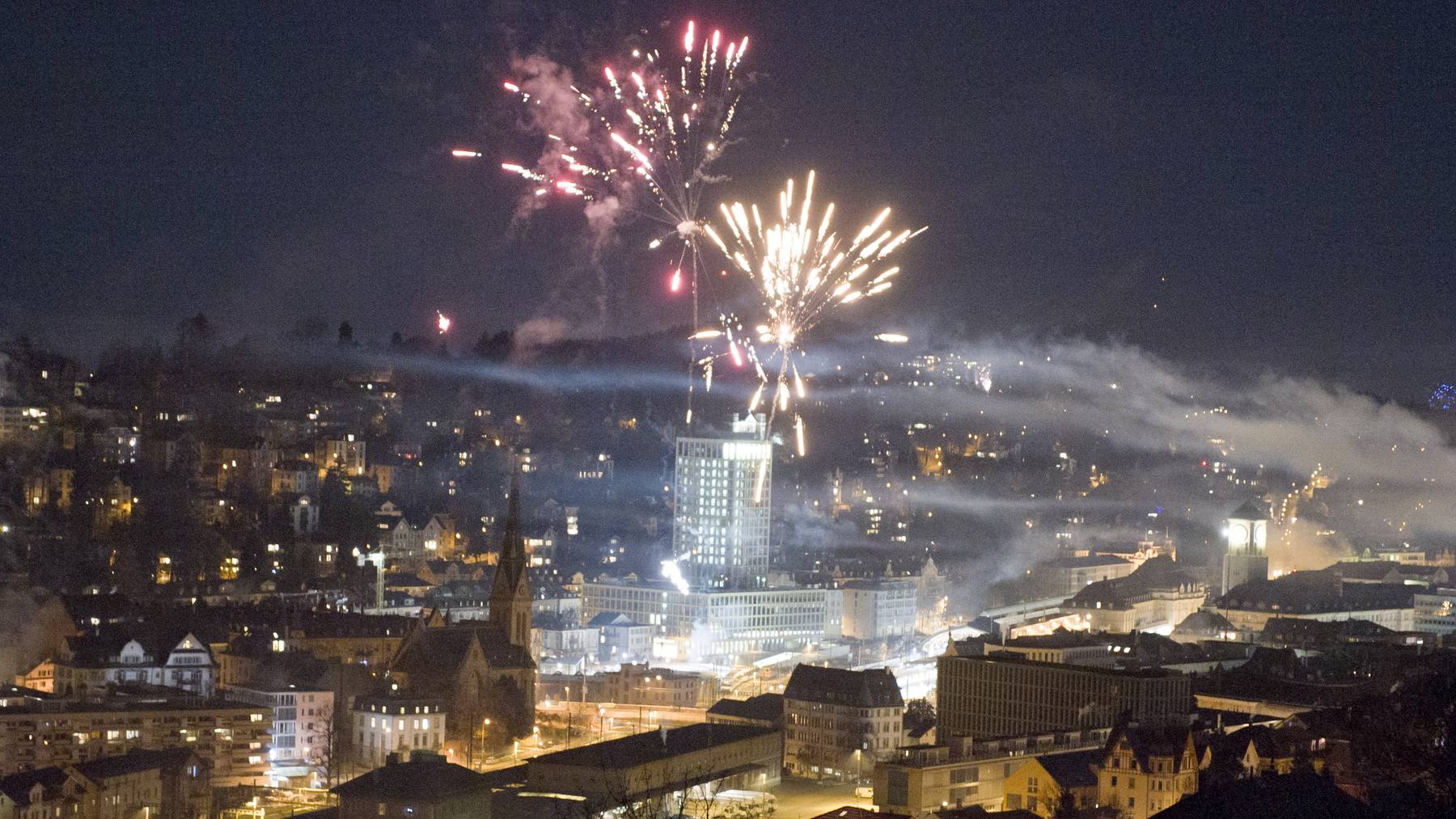Rauch und Neujahrs-Feuerwerke über der Stadt St.Gallen in einer Silvesternacht.