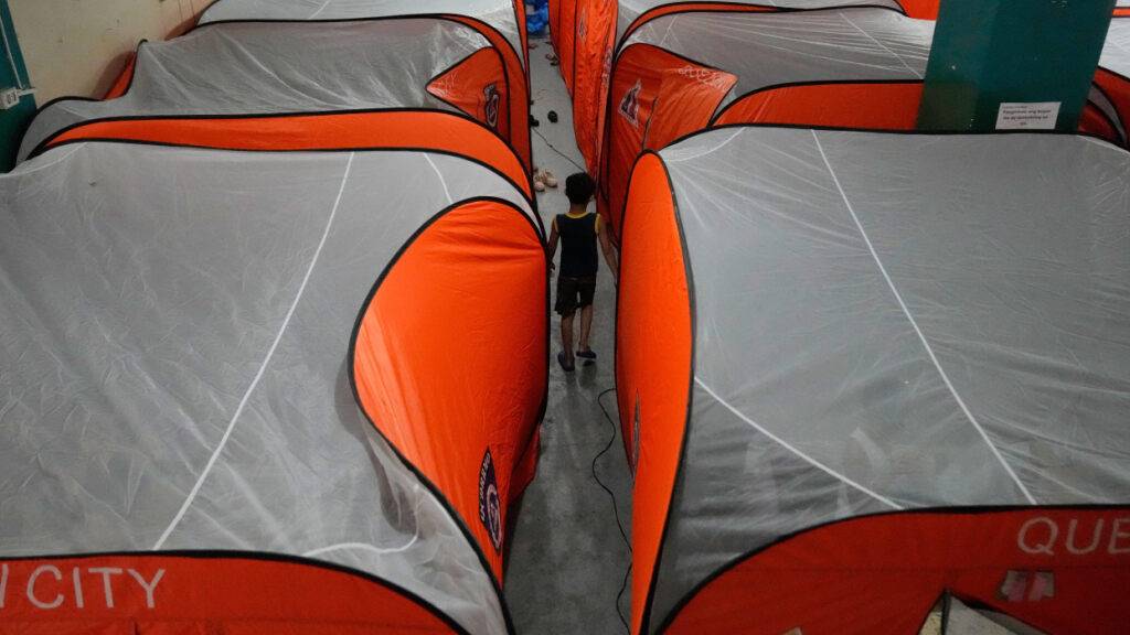Ein Junge geht zwischen Zelten in einem Evakuierungszentrum umher, als der Taifun Fung-wong in Quezon City auf den Philippinen ins Land zieht. Foto: Aaron Favila/AP/dpa