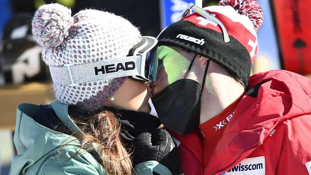 Beat Feuz küsst Katrin Triendl, seine Partnerin und Mutter von Tochter Clea