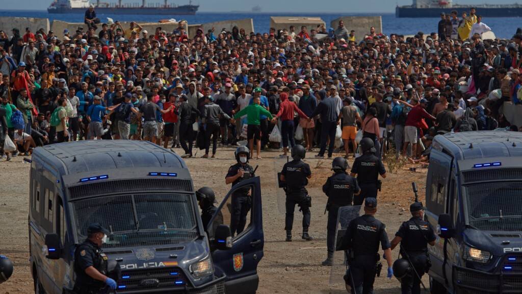 dpatopbilder - Migranten, die von Marokko nach Spanien eingereist waren, kehren von der Polizei begeleitet an einen Strand in der spanischen Exklave Ceuta zurück. Foto: Antonio Sempere/AP/dpa/Archivbild