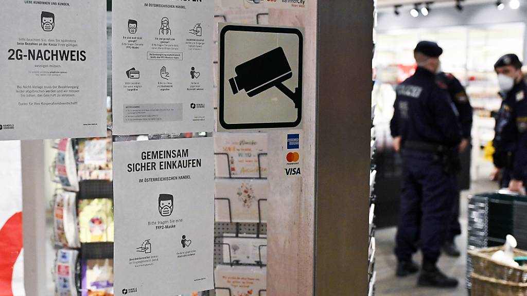 Hinweisschilder sind neben dem Eingang eines Geschäfts in Wien angebracht, die Informationen darüber geben, dass nur Personen mit einem 2G-Nachweis, Personen die vom Coronavirus genesen oder geimpft sind, in diesem Laden einkaufen dürfen. Foto: Hans Punz/APA/dpa