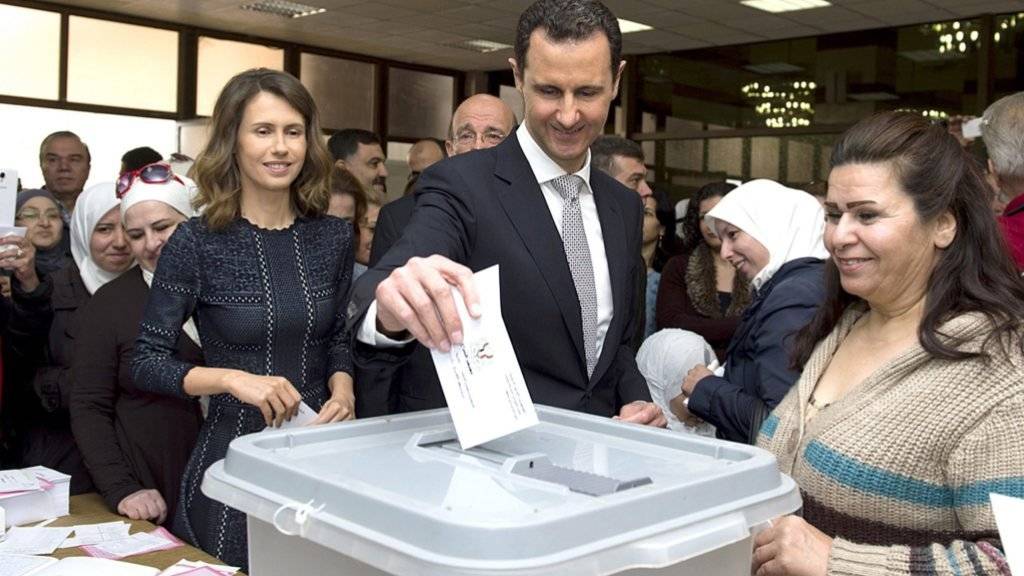 Präsident Assad (M) uns seine Frau (l) legen in Damaskus ihre Wahlzettel in die Urne: Nur in Gebieten Syriens, die unter der Kontrolle der Regierung sind, wurde gewählt.