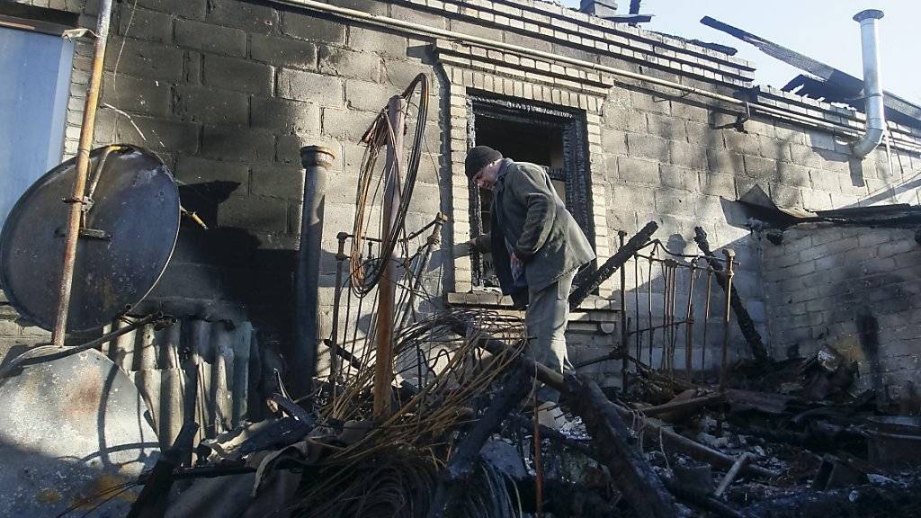 Ein Mann steht in den Trümmern eines Hauses, das bei heftigem Beschuss in der Nähe von Donezk zerstört wurde.