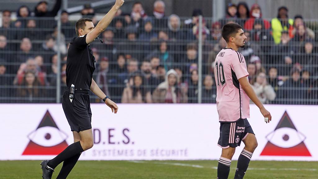 Referee Johannes von Mandach zeigt Enzo Crivelli (nicht im Bild) die Rote Karte; Servettes Torschütze Alexis Antunes beobachtet die Szene