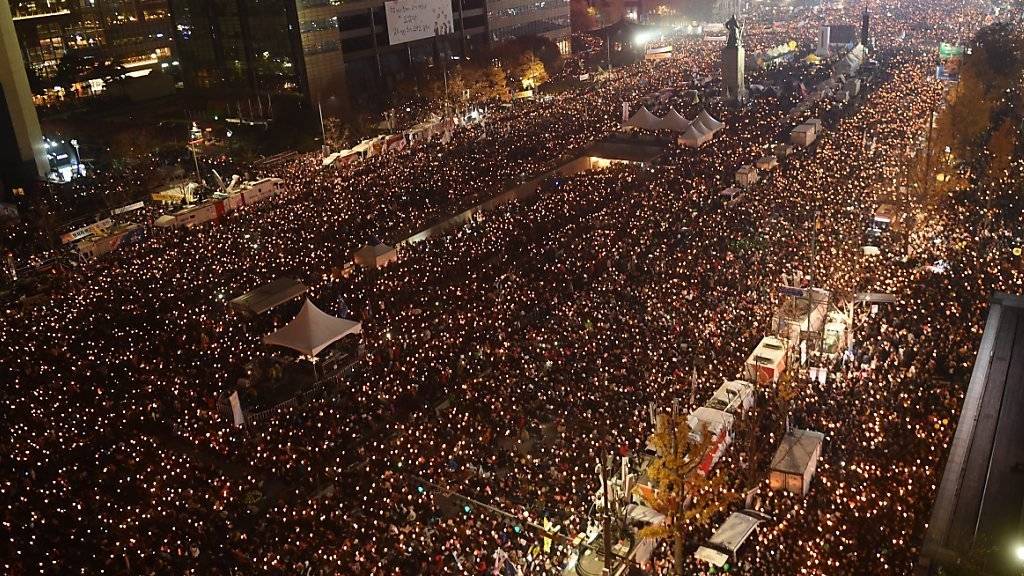 In Südkoreas Hauptstadt demonstrieren Tausende gegen Präsidentin Park Geun-Hye. Mit Kerzen gingen die Menschen auf die Strasse und forderten den Rücktritt von Park.
