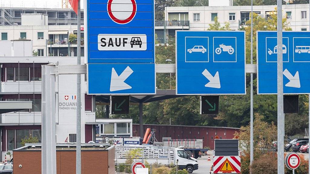Massnahmen gegen die täglich rollende Verkehrslawine: Ein neues Schild (links) markiert die eigene Spur für Fahrgemeinschaften am Grenzübergang Thônex-Vallard bei Genf.