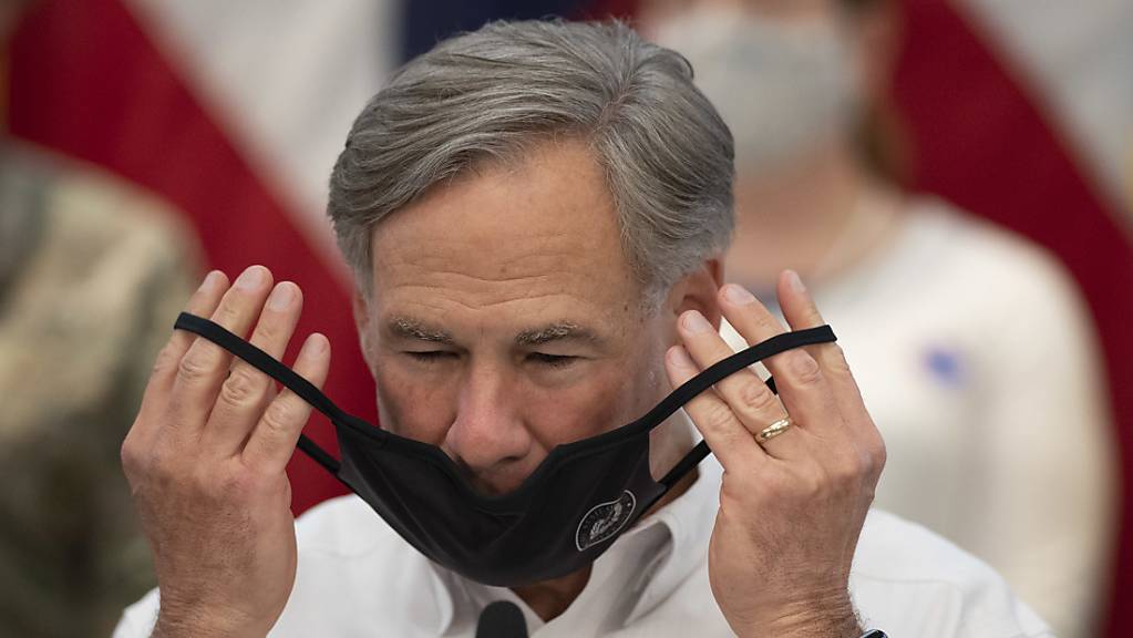 Greg Abbott, Gouverneur von Texas, setzt eine Gesichtsmaske während eines Interviews zum Hurrikan «Laura» einen Mundschutz auf.