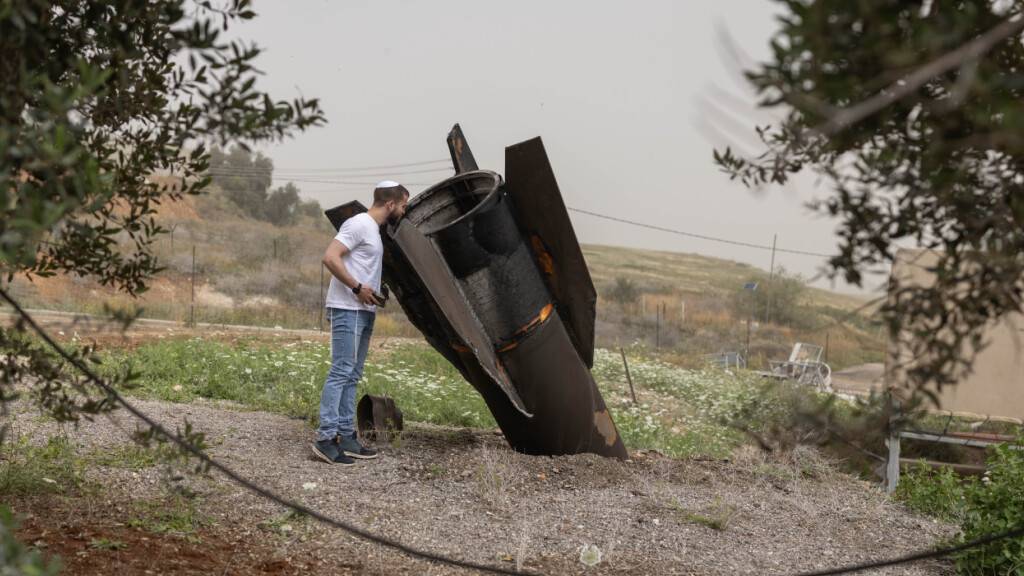 ARCHIV - Ein israelischer Mann betrachtet in der jüdischen Siedlung im nördlichen Jordantal das Heckteil einer vom Iran abgeschossenen ballistischen Rakete. Foto: Oren Ziv/dpa