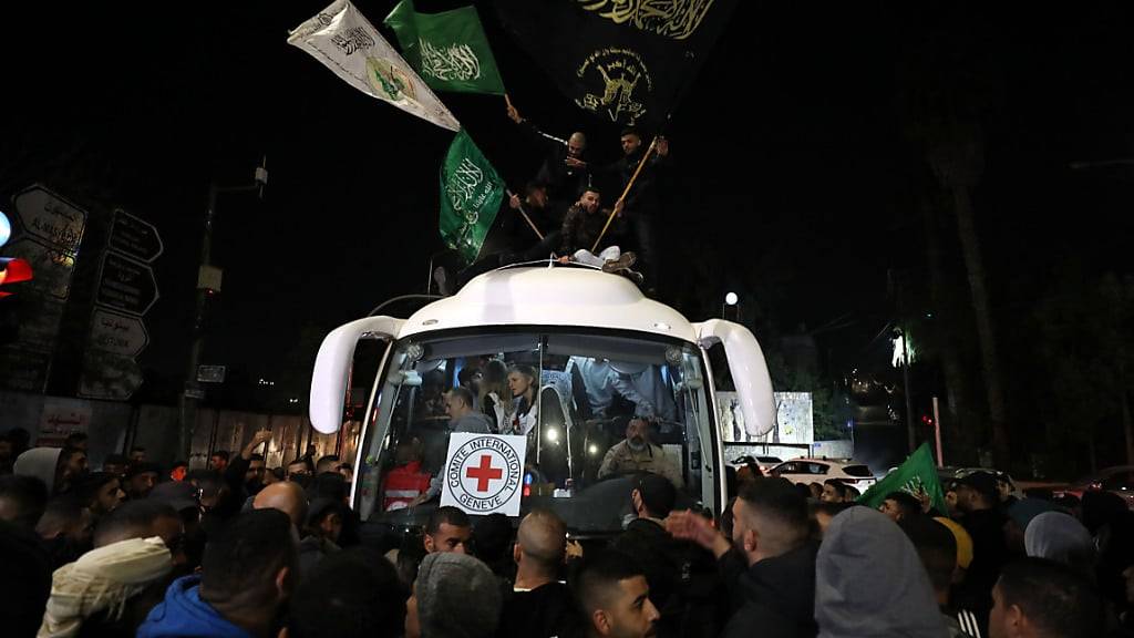 Ein Bus mit Mitarbeiter des Roten Kreuzes und palästinensischen ehemaligen Gefangenen, die im Rahmen eines Geisel-/Gefangenenaustauschs zwischen der islamistischen Hamas und Israel aus einem israelischen Gefängnis entlassen wurden kommt in Ramallah an. Die islamistische Hamas hat eine weitere Gruppe von Geiseln im Rahmen der Feuerpause im Gaza-Krieg dem Roten Kreuz übergeben. Foto: Ayman Nobani/dpa