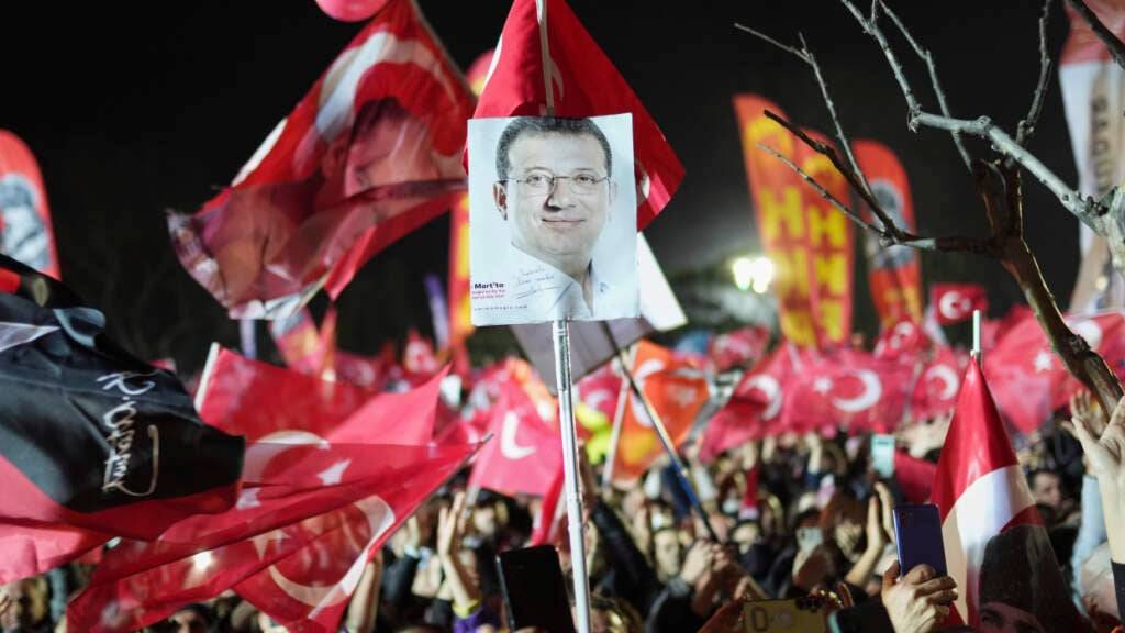 ARCHIV - Demonstranten schwenken Fahnen und halten Bilder des festgenommenen Istanbuler Bürgermeisters Imamoglu hoch während eines Protests gegen die nationale Regierung. Foto: Francisco Seco/AP/dpa