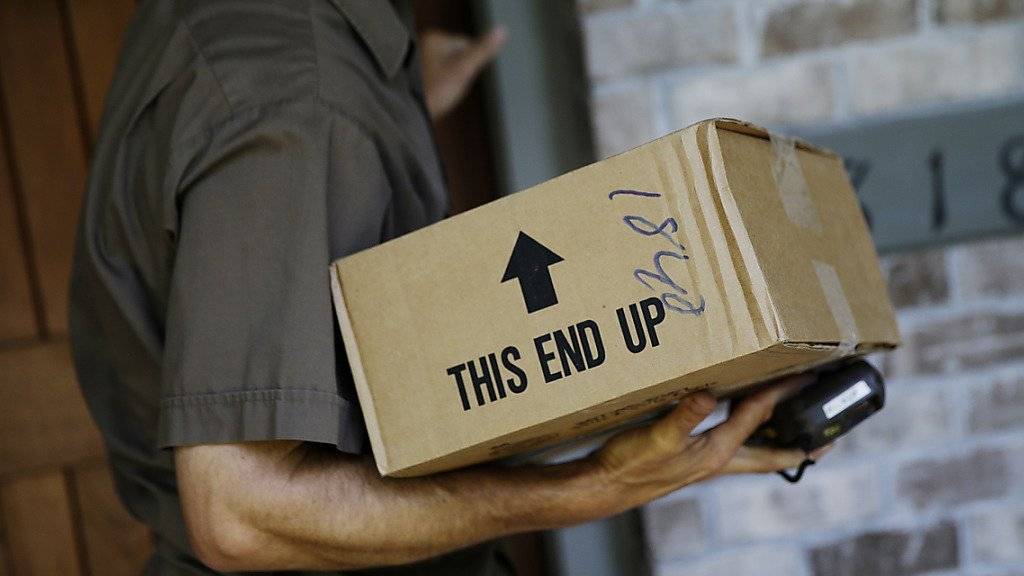 Ein UPS-Fahrer bringt ein Paket an die Haustüre: Zu Weihnachten braucht es viel mehr dieser Fahrer. UPS stellt deshalb 95'000 Aushilfen ein.