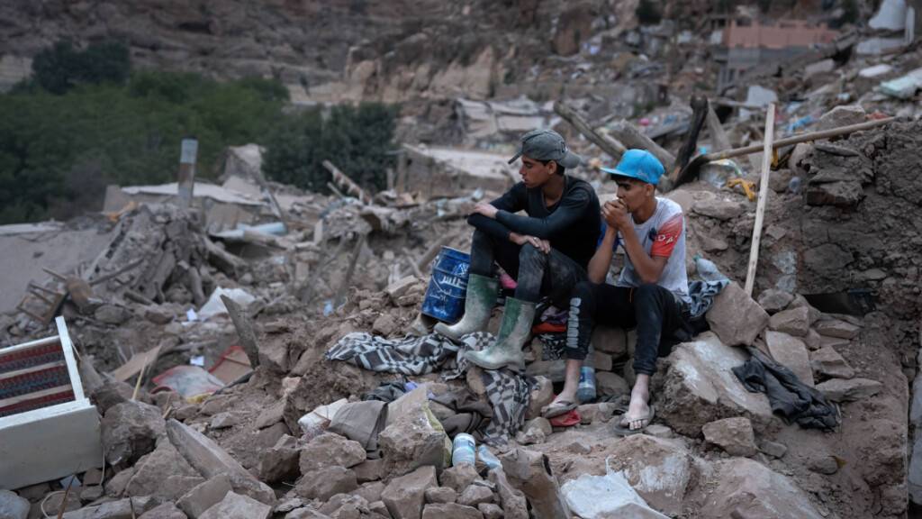 Teenager beobachten im Dorf Imi N'Tala im marokkanischen Atlasgebirge die Suche nach einem möglichen Überlebenden. Foto: Ximena Borrazas/SOPA Images via ZUMA Press Wire/dpa