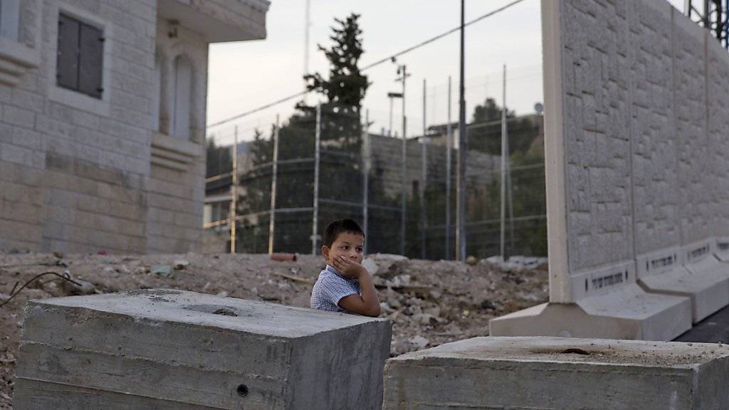 Ein Palästinenser-Junge steht vor den Mauer-Elementen, die von Israel zwischen Dschabal Mukaber und Armon Hanaziv errichtet werden.
