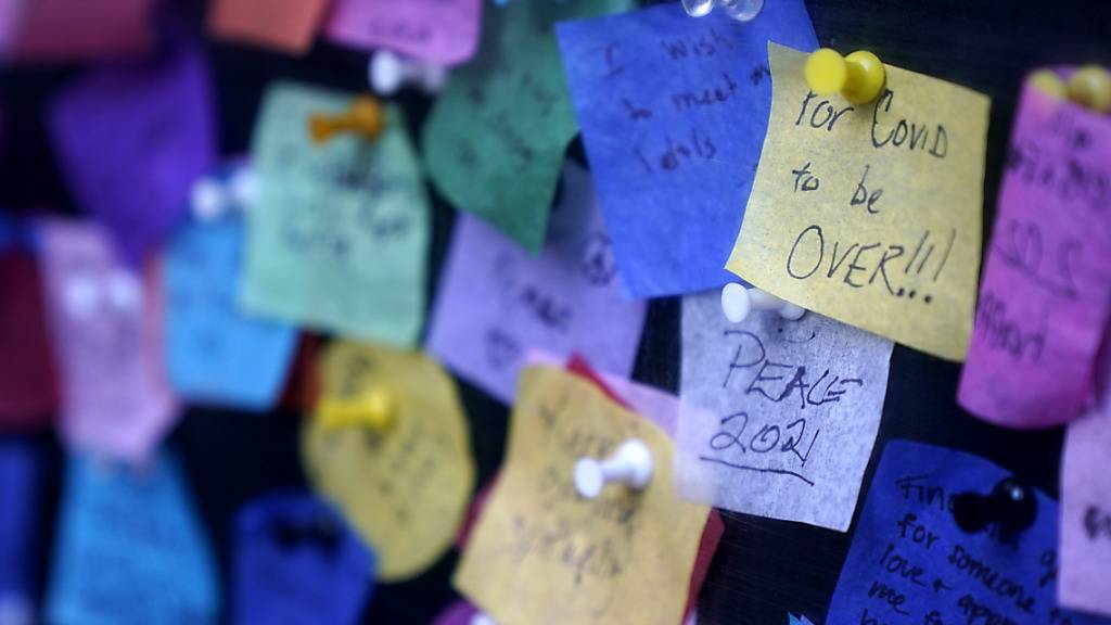 Botschaften, die Menschen auf buntes Papier geschrieben haben, sind am Times Square zu sehen. Foto: Seth Wenig/AP/dpa