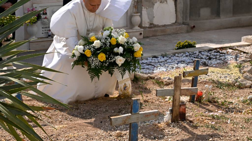 dpatopbilder - Papst Leo XIV. legt auf dem Friedhof und am Grab des kleinen Joussef in Lampedusa auf Sizilien Blumen nieder. Er befindet sich dort im Rahmen eines eintägigen Pastoralbesuchs auf der Insel, die zu einem Symbol für die Gefahren geworden ist, denen Migranten ausgesetzt sind. Foto: Ciro Fusco/Ansa POOL/AP/dpa