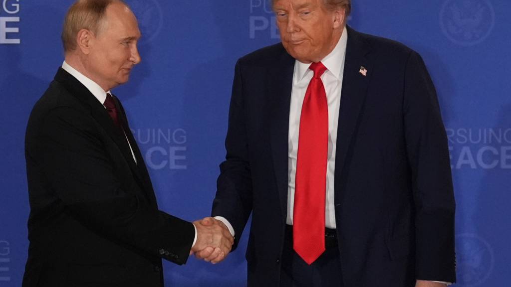 RECROP - US-Präsident Donald Trump (r) schüttelt die Hand des russischen Präsidenten Wladimir Putin während einer gemeinsamen Pressekonferenz auf der Joint Base Elmendorf-Richardson, Alaska. Foto: Jae C. Hong/AP/dpa