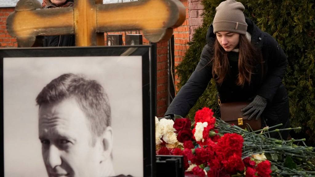 ARCHIV - Eine Frau legt ein Jahr nach dem Tod des russischen Oppositionsführers Alexej Nawalny auf dem Borisowskoje-Friedhof in Moskau Blumen nieder. Foto: AP/dpa/Archivbild