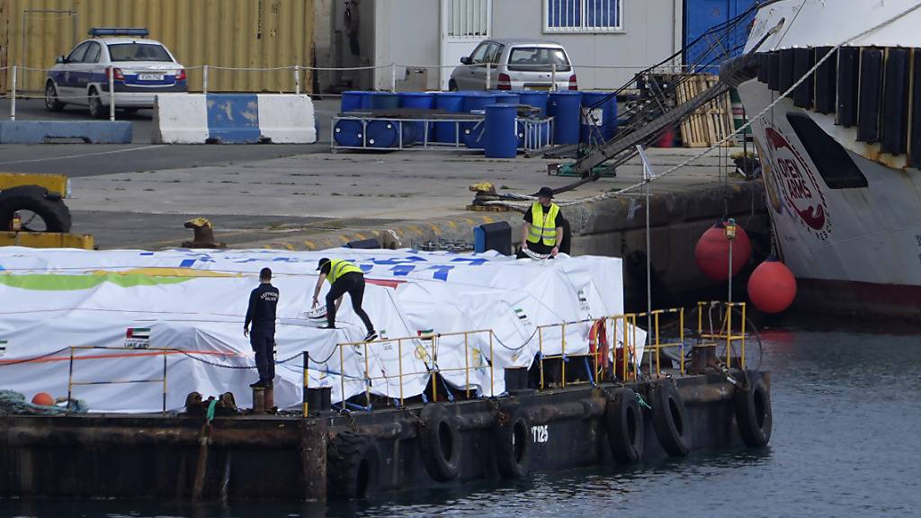 Hafenmitarbeiter bereiten Hilfsgüter für den Gazastreifen auf einer Plattform neben dem angedockten Schiff der Hilfsorganisation Open Arms vor. Das Schiff der spanischen Hilfsorganisation soll zum Auftakt eines angekündigten Seekorridors zunächst rund 200 Tonnen Lebensmittel von Zypern aus transportieren und in den nächsten Tagen eintreffen, wie der britische Sender BBC meldete. Foto: Petros Karadjias/AP/dpa