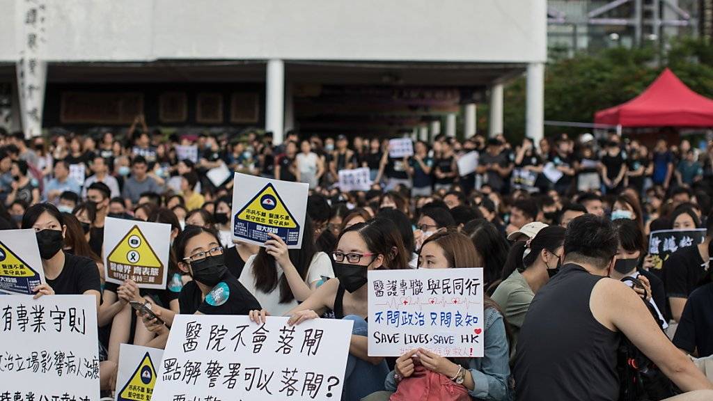 Mit Gesichtsmaske an der Demonstration: Staatsbedienstete auf der Strasse in Hongkong.