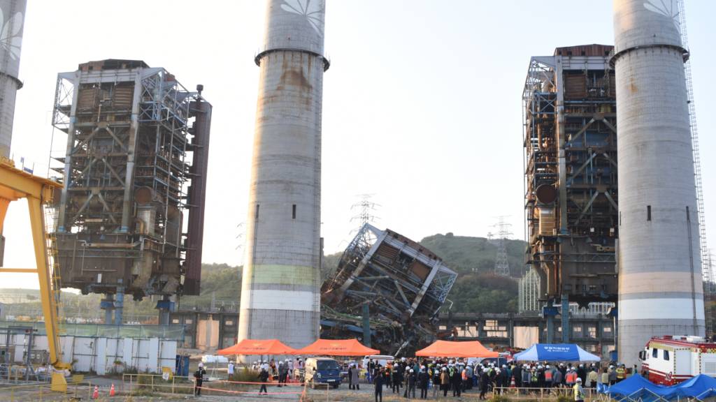 Ein Rettungsteam arbeitet in der Nähe eines 60 Meter hohen Turms, der bei Abbrucharbeiten in einem stillgelegten Wärmekraftwerk in Ulsan, Südkorea, zusammengebrochen ist. Foto: Uncredited/NEWSIS/dpa