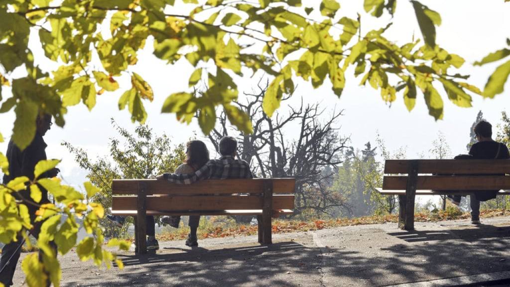 Menschen geniessen die warmen Sonnenstrahlen des Herbstes in Zürich. (Archivbild)