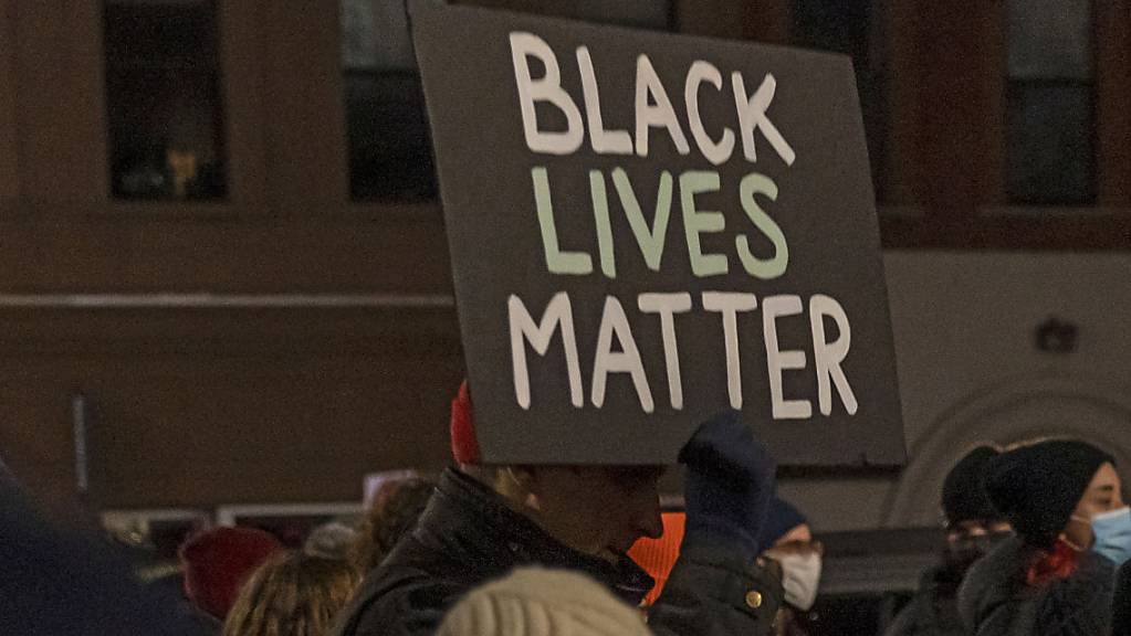Ein Demonstrant hält ein Schild mit der Aufschrift «Black Lives Matter» während eines Protestmarsches gegen den Freispruch von Kyle R. hoch. Der Angeklagte ist in dem viel beachteten Prozess um den gewaltsamen Tod von zwei Menschen bei Anti-Rassismus-Protesten im vergangenen Jahr freigesprochen worden. Foto: Ron Adar/SOPA Images via ZUMA Press Wire/dpa
