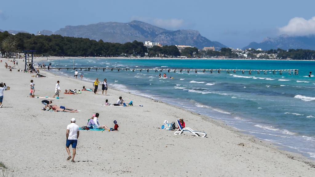 ARCHIV - Menschen verbringen ihre Freizeit am Strand von Mallorca. Foto: Clara Margais/dpa