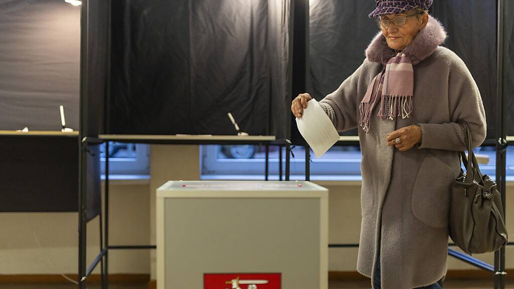 dpatopbilder - Eine Frau gibt ihre Stimme in einem Wahllokal in Vilnius ab während des zweiten Wahlgangs der Parlamentswahlen in Litauen. Foto: Mindaugas Kulbis/AP/dpa