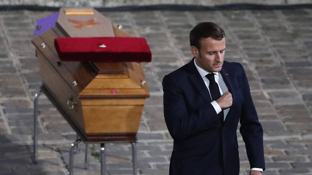 Der französische Staatspräsident Emmanuel Macron wendet sich bei der Gedenkveranstaltung  für Samuel Paty vom Sarg des ermordeten Lehrers ab.