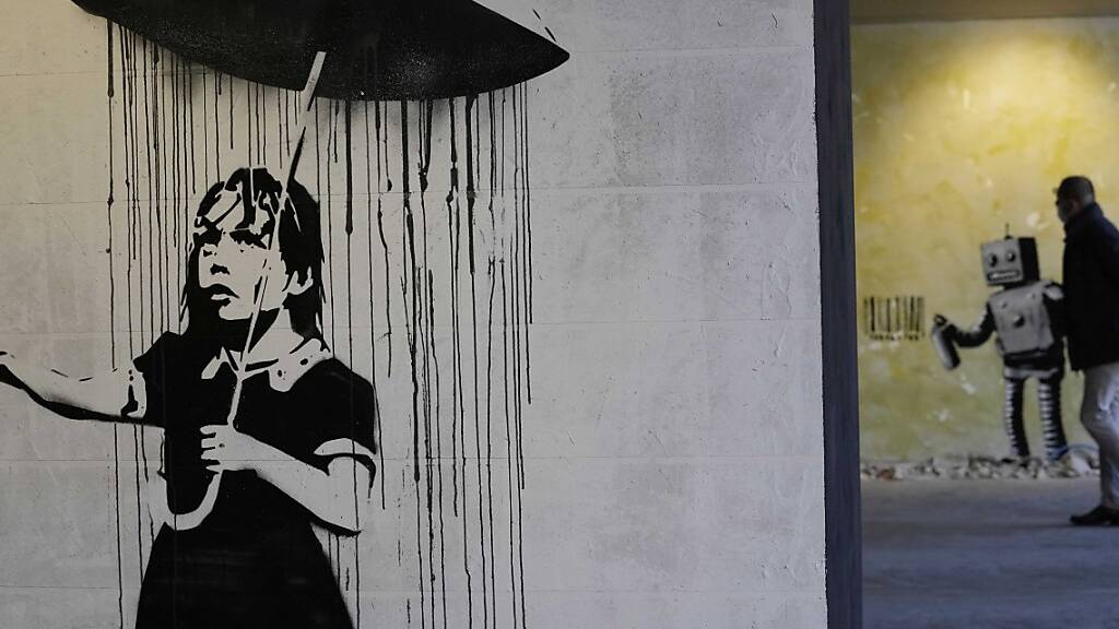 «The Umbrella girl», eine Reproduktion eines Wandgemäldes des britischen Künstlers Banksy. Foto: Luca Bruno/AP/dpa - ACHTUNG: Nur zur redaktionellen Verwendung und nur mit vollständiger Nennung des vorstehenden Credits