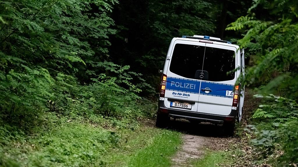 Ein Polizeiwagen fährt auf der Suche nach einem gefährlichen Wildtier in Berlin-Zehlendorf im Bereich der südlichen Landesgrenze von Berlin durch den Wald. Foto: Fabian Sommer/dpa