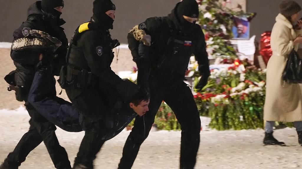 ARCHIV - Polizeibeamte halten im Februar einen Mann fest, der Blumen zu Ehren von Alexej Nawalny an einem Denkmal für die Opfer der sowjetischen Unterdrückung in St. Petersburg, Russland, niedergelegt hat Foto: Uncredited/AP/dpa