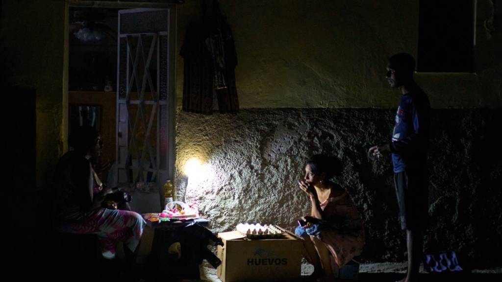 ARCHIV - Straßenverkäufer unterhalten sich während eines Stromausfalls in Havanna. Foto: Ramon Espinosa/AP/dpa