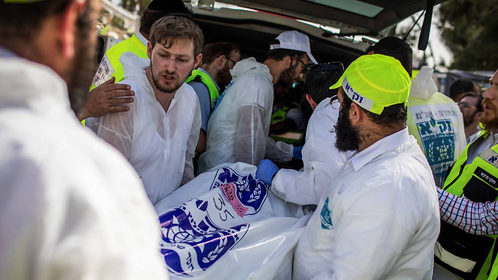 Israelische Rettungskräfte tragen den Leichnam eines Opfers, an der jüdisch-orthodoxen Pilgerstätte des Berges Meron, wo Dutzende von Gläubigen bei einer Massenpanik während des jüdischen religiösen Festes Lag BaOmer im Norden Israels getötet wurden.